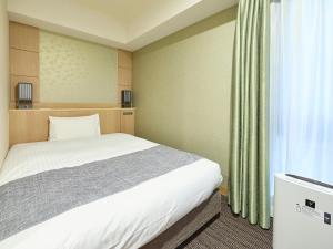 a bedroom with a white bed and a window at Vessel Hotel Campana Kyoto Gojo in Kyoto