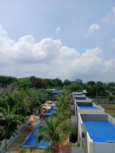 a row of buildings with blue roofs and palm trees at paparazzi homestay in Xuyên Mộc