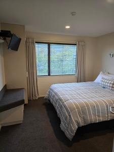 una camera da letto con un letto e una grande finestra di Cedar Grove Motor Lodge a Nelson