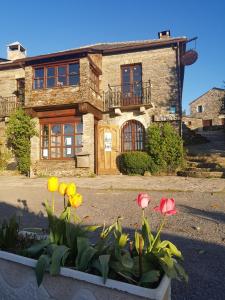 a house with flowers in front of it at Casa Carolo in O Cebrero