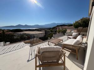 a balcony with wicker chairs and a view of the ocean at Calvi - A Casa di u Mare in Calvi