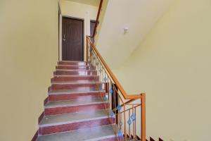a stairway with a wooden door and a stair case at SPOT ON SR Dream Home in Goa