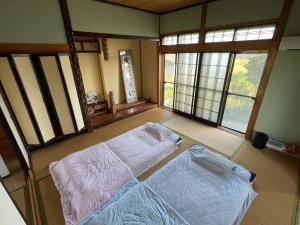a bedroom with two beds in a room with windows at Tanonagano Yadokko - Vacation STAY 26911v in Goshogawara