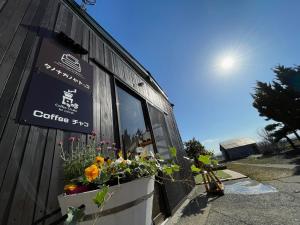 a window of a coffee shop with flowers in it at Tanonagano Yadokko - Vacation STAY 26911v in Goshogawara +7 photos
