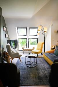 a living room with a couch and chairs and a table at Magnifique maison de famille - Entre terre et mer in Fouesnant