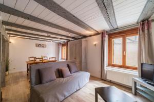 a living room with a couch and a tv at Le studio in Turckheim