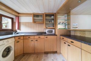 a kitchen with wooden cabinets and a washer and dryer at Le studio in Turckheim +6 photos