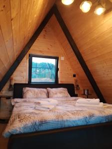 a bedroom with a bed in a attic at A Frame Vila sa Saunom Jakuzi kadom i toplim bazenom in Koraćica