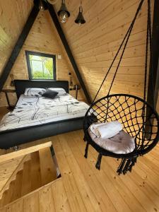 a room with a bed and a swing in a cabin at A Frame Vila sa Saunom Jakuzi kadom i toplim bazenom in Koraćica