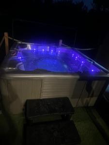 a blue hot tub with lights in the dark at A Frame Vila sa Saunom Jakuzi kadom i toplim bazenom in Koraćica