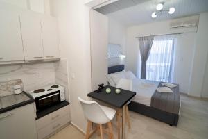 eine kleine Küche mit Bett und Tisch in einem Zimmer in der Unterkunft Chariklia Studios in Asmínion