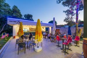 a group of people sitting at tables and chairs with umbrellas at Katre Hotel Oludeniz in Oludeniz