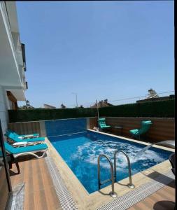 a swimming pool with two chairs in a house at Villa Aile in Eskiömerler
