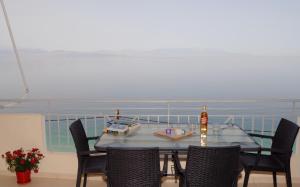 a dining room with a table and chairs and the ocean at Akrata Beach Quality Furnished Apartments in Paralía Akrátas +3 photos
