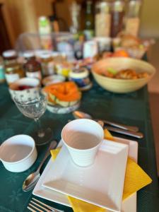 a table topped with plates and bowls of food at Arduinna's Nest B&B in Neufchâteau