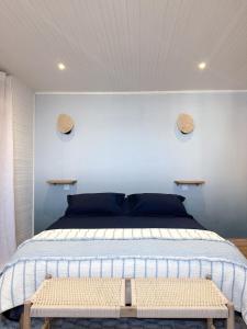 ein Schlafzimmer mit einem Bett und einer weißen Wand in der Unterkunft L'Heurt Bleue - Maison de pêcheur face mer in Le Portel