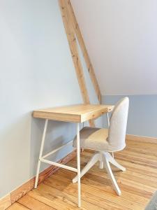 einen Holzschreibtisch mit einem Stuhl neben einer Wand in der Unterkunft L'Heurt Bleue - Maison de pêcheur face mer in Le Portel + 23 Fotos
