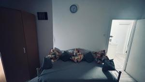 a bedroom with a bed with pillows and a clock on the wall at Sibejdo 1&2 in Varaždin