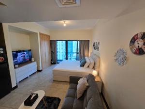 una sala de estar con una cama y un sofá en Click Stay - JLT - Entire Studio & Balcony Lakes view Apartment -NA, en Dubái