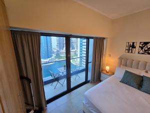 Un dormitorio con una cama y un balcón con vistas. en Click Stay - JLT - Entire Studio & Balcony Lakes view Apartment -NA, en Dubái 58 fotos más