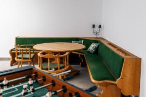 a living room with a green couch and a table at Danner Appartements Wolfsegg am Hausruck- Ferienwohnung & Business-Appartements Ruhige Lage, moderne Ausstattung, faire Preise in Wolfsegg am Hausruck