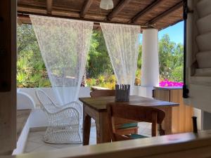 a porch with a table and chairs and a window at JERA Holiday Collection VULCANO DUE - Garden View in Vulcano