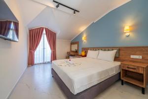 a bedroom with a large white bed and a window at Katre Hotel Oludeniz in Oludeniz