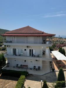 ein großes weißes Haus mit einem Dach in der Unterkunft Vila Ervin First Floor in Ksamil