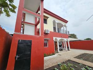 a red and white house with a black garage at Maison d'hôte de marque in Pointe-Noire