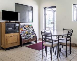 a dining room with a table and a tv at KCI Lodge in Kansas City