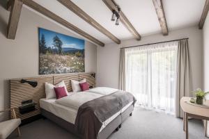 a bedroom with a bed and a large window at Harztrail Lodge in Ilsenburg