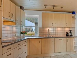 a kitchen with wooden cabinets and a window at Very Nice Villa in Rødbyhavn in Rødby