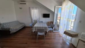 ein Esszimmer mit Tisch und Stühlen und einer Couch in der Unterkunft Apartments Zvonimir,place by the sea in Mirce