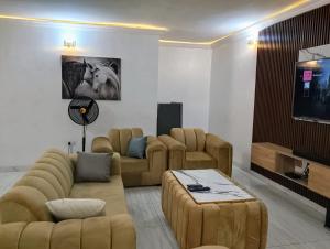 a living room with couches and a flat screen tv at Memento Courts in Lagos