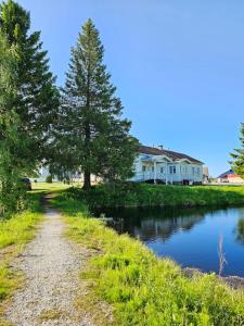 a path next to a river with houses in the background at Pohjanranta Cottages in Keminmaa