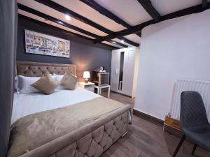 a bedroom with a large bed and a chair at The Courtyard Lodge in Hitchin +66 photos