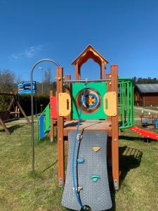 a playground in a park with a slide at Plażowa Domki in Mielenko