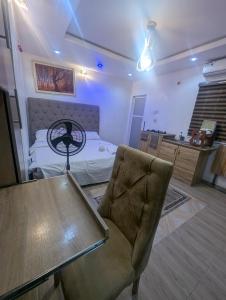 a bedroom with a bed and a table and a chair at Memento Courts in Lagos