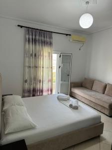 a bedroom with a large bed and a couch at Vila Ervin Double Room in Ksamil +5 photos