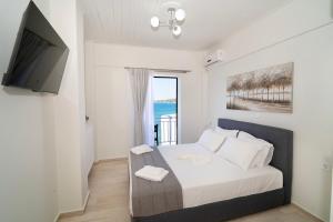 ein Schlafzimmer mit einem Bett und einem Flachbildfernseher in der Unterkunft Chariklia Studios in Asmínion
