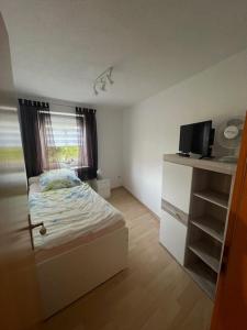 Un dormitorio pequeño con una cama y una ventana. en Ferienwohnung Matthias Lang, en Rugendorf