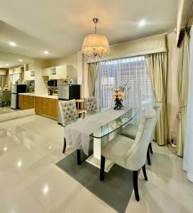 a dining room with a glass table and chairs at Peters Villa in Ban Nakhon Chum