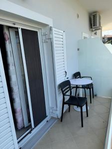 a balcony with a table and chairs in a room at Vila Ervin Double Room in Ksamil