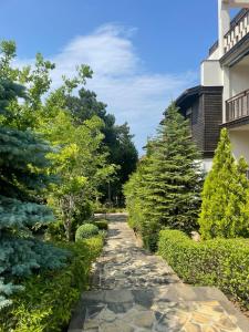 a garden with trees and a stone path at Apartment at the Seaside in Sozopol
