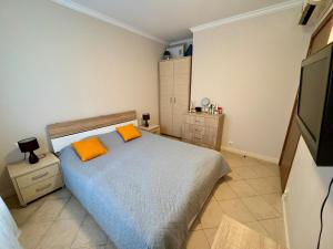 a bedroom with a bed with two orange pillows at Apartment at the Seaside in Sozopol +29 photos
