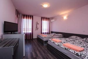 a room with two beds and a flat screen tv at Calisto Villas Arapya in Arapya