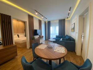 una sala de estar con un sofá, una mesa y sillas en Omorika Lux, en Zlatibor 31 fotos más