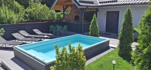 a swimming pool in a yard with chairs and a house at Vila Casa Din Vale - Valiug in Văliug