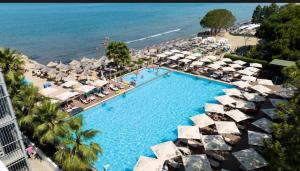 an overhead view of a swimming pool with umbrellas and a beach at Lovely Rooftop Apartment in Golem