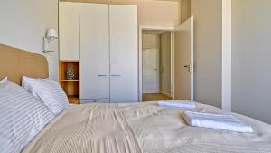 a bedroom with a bed with two towels on it at Ostseeresidenz Niechorze D305 Eco Boho - 5D Apartments in Niechorze